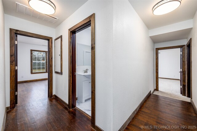 719 W Evergreen, Durant, OK 74701 - corridor featuring baseboards, dark wood finished floors, visible vents, and a sink