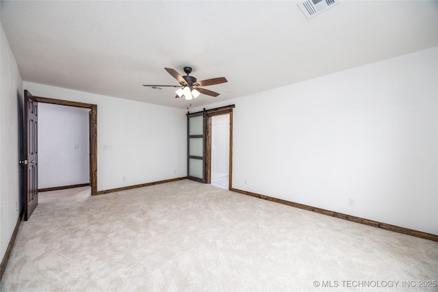719 W Evergreen, Durant, OK 74701 - unfurnished room with a barn door, visible vents, ceiling fan, light carpet, and baseboards