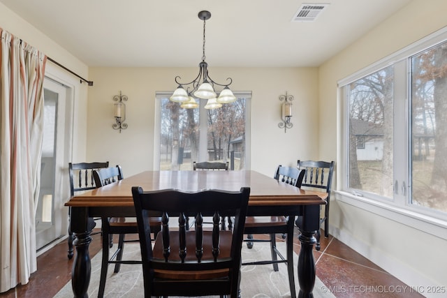 dining space featuring a chandelier, visible vents, and baseboards