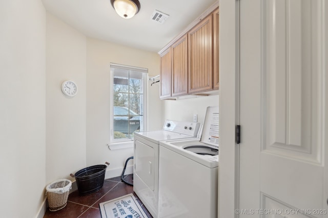 laundry area featuring dark tile patterned flooring, separate washer and dryer, visible vents, baseboards, and cabinet space