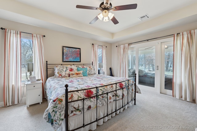 bedroom with access to exterior, visible vents, light carpet, and multiple windows