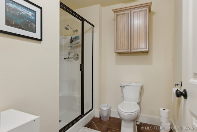 full bathroom featuring toilet, a shower stall, baseboards, and tile patterned floors