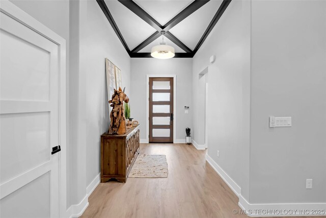 foyer with baseboards, light wood-type flooring, and beam ceiling