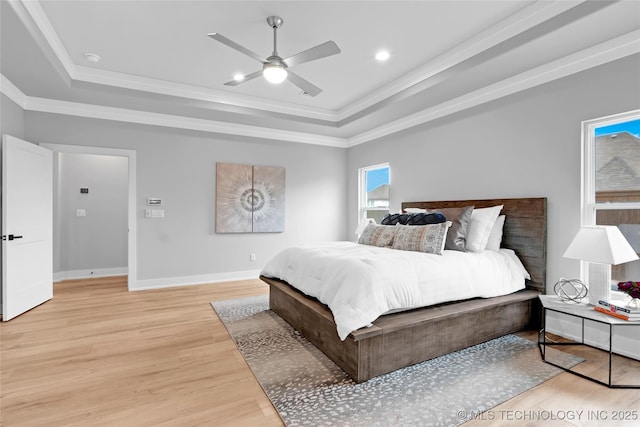 bedroom featuring crown molding, light wood-type flooring, and a raised ceiling
