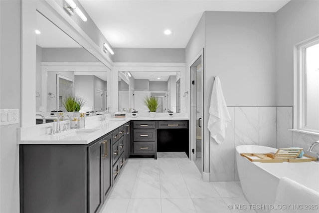 bathroom featuring a freestanding bath, vanity, and a shower stall
