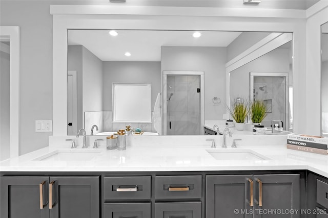 full bathroom with double vanity, a sink, recessed lighting, and a shower stall