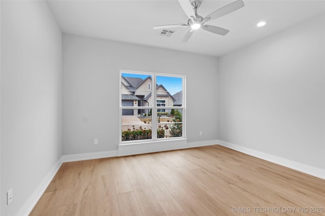 unfurnished room with wood finished floors, baseboards, ceiling fan, and visible vents