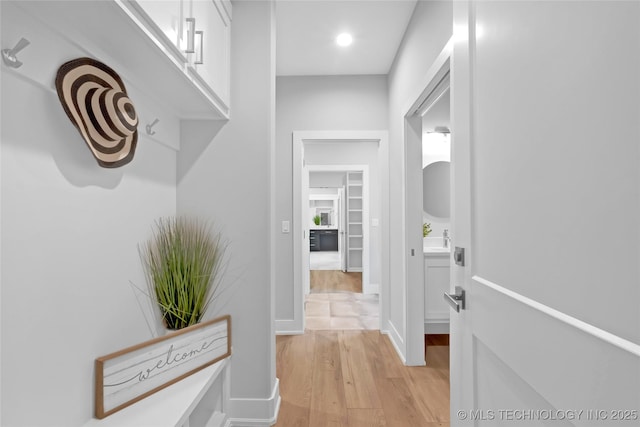 hallway featuring baseboards and light wood-style flooring