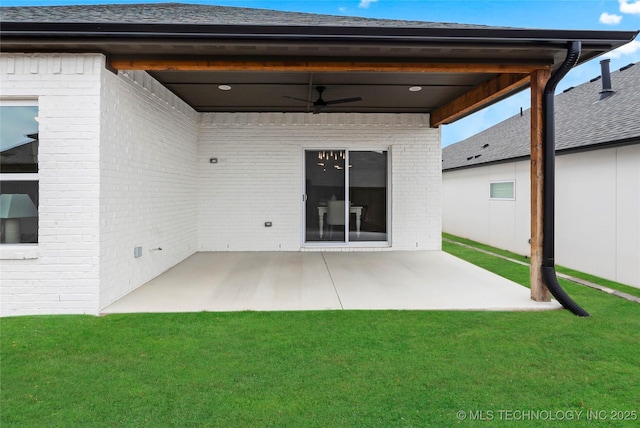rear view of house featuring brick siding, a lawn, ceiling fan, and a patio area