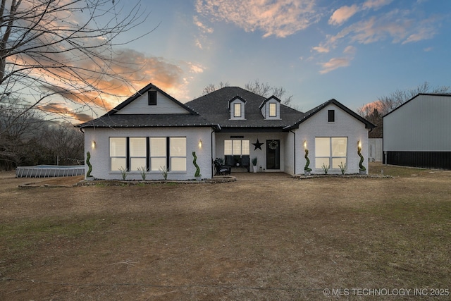 back house at dusk featuring a yard