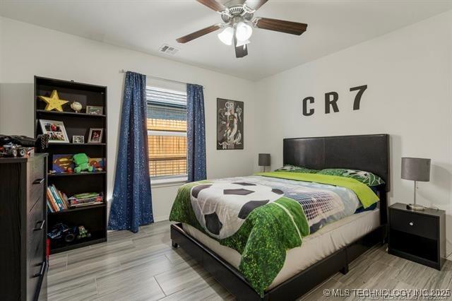 bedroom with light hardwood / wood-style flooring and ceiling fan