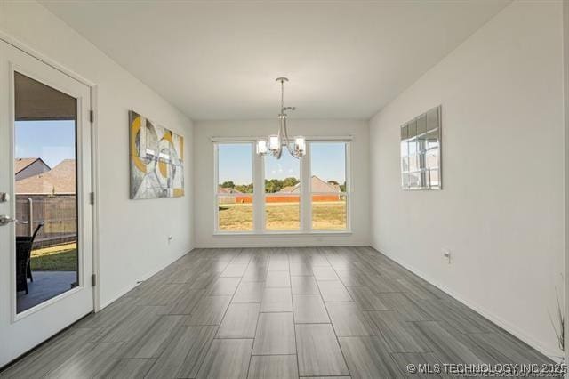 unfurnished dining area featuring a notable chandelier