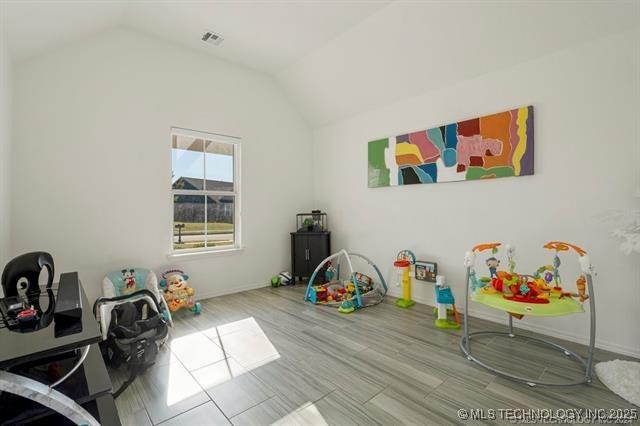 rec room with light hardwood / wood-style flooring and vaulted ceiling