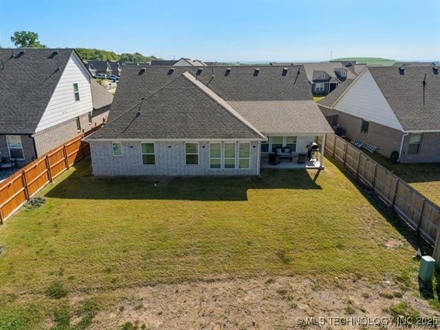 rear view of house featuring a yard and a patio