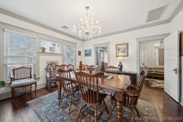 dining area with dark wood-type flooring, crown molding, and a chandelier