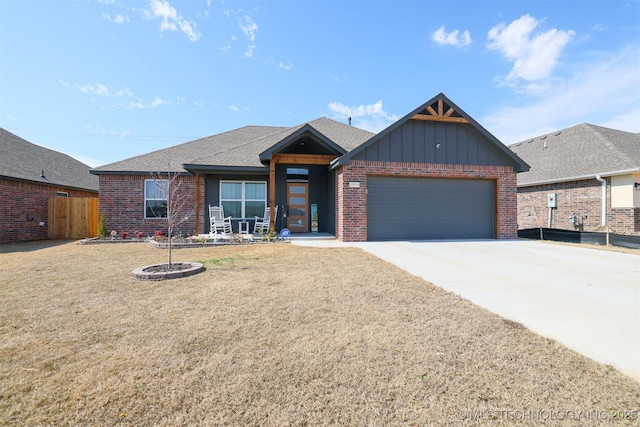 view of front of property with a garage, driveway, brick siding, and board and batten siding