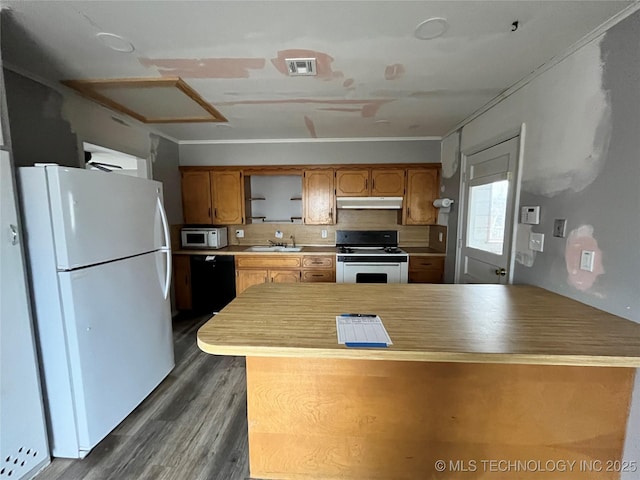 kitchen featuring sink, kitchen peninsula, white appliances, and dark wood-type flooring