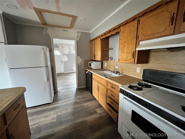 kitchen with sink, dark wood-type flooring, white appliances, and backsplash