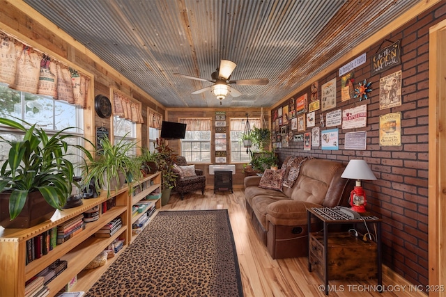 living area featuring wood ceiling, plenty of natural light, wood finished floors, and ceiling fan