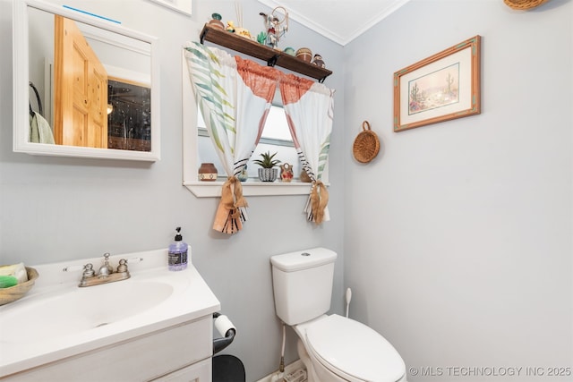 bathroom featuring vanity, toilet, and ornamental molding