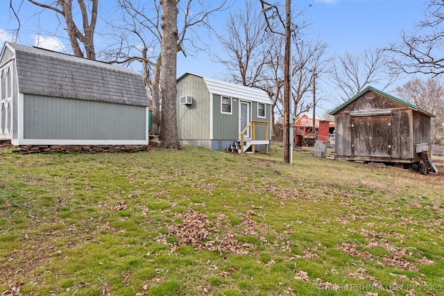 view of yard with an outbuilding, a storage shed, and a wall unit AC