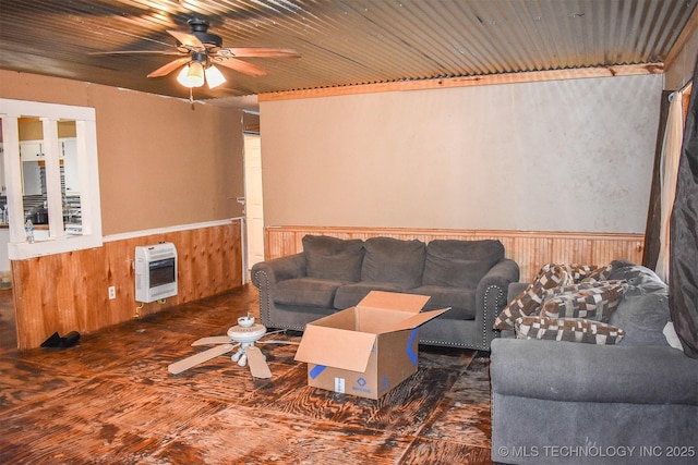 living room featuring heating unit, wooden walls, wood ceiling, and ceiling fan