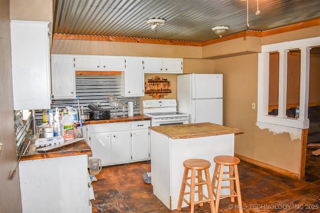 kitchen featuring white cabinetry, white appliances, a kitchen bar, and a center island