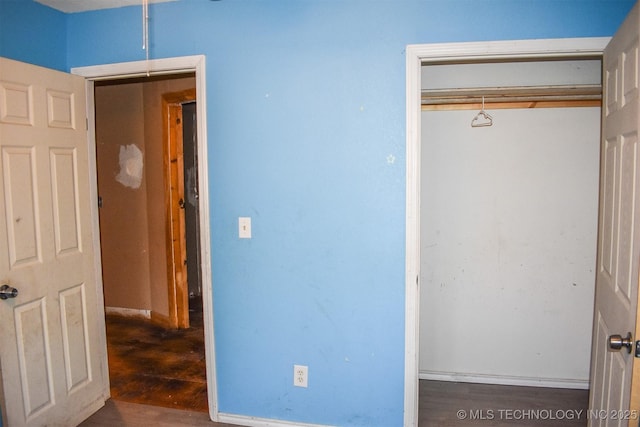 unfurnished bedroom with a closet and dark hardwood / wood-style floors