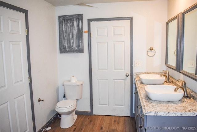 bathroom with vanity, toilet, and hardwood / wood-style floors