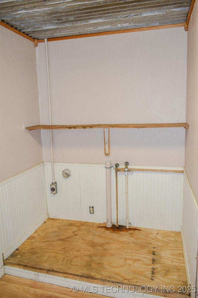 washroom with a wainscoted wall, washer hookup, wood finished floors, and laundry area