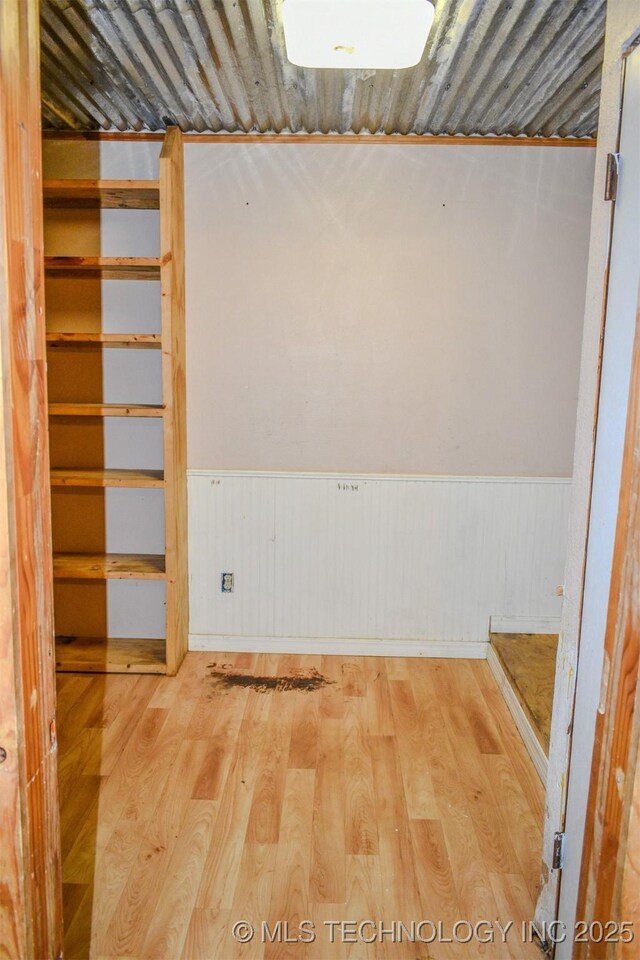 empty room featuring a wainscoted wall and wood finished floors