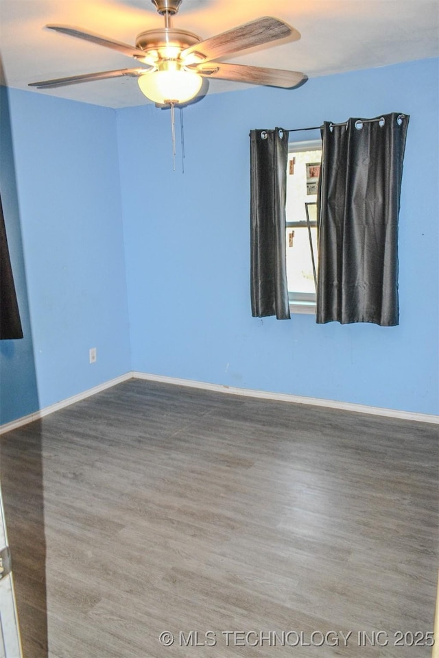 empty room featuring a ceiling fan, baseboards, and wood finished floors