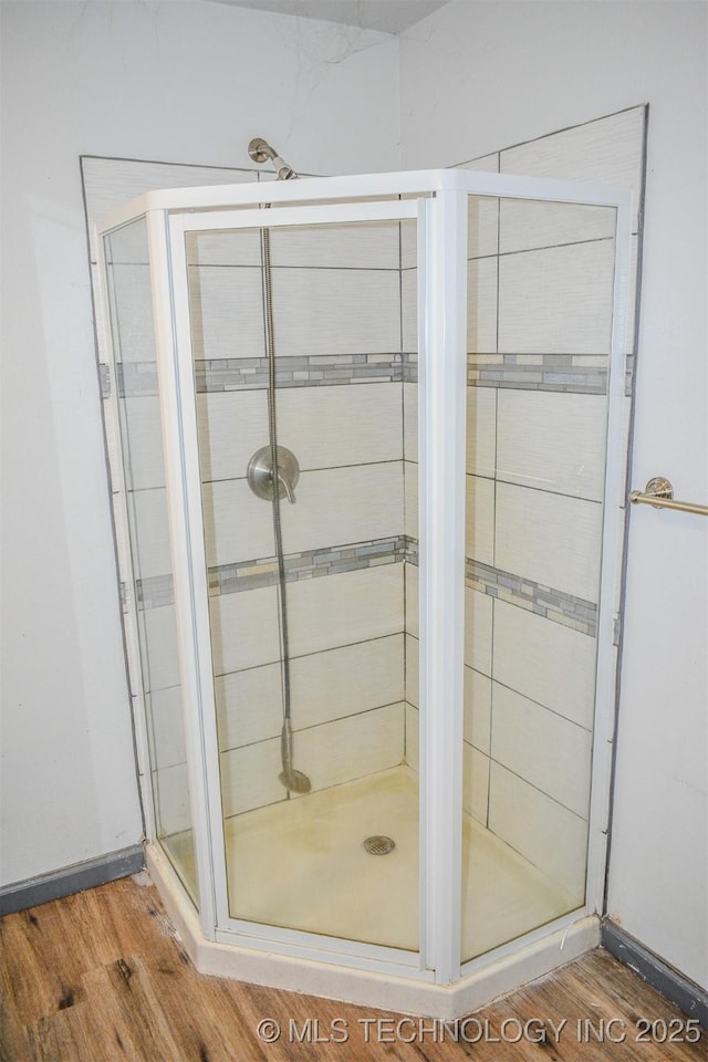 full bath with wood finished floors and a shower stall