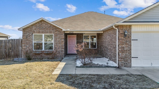 single story home featuring a garage and a front lawn