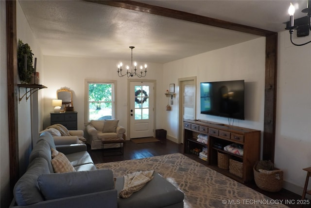 living room with a textured ceiling, dark hardwood / wood-style floors, and a notable chandelier