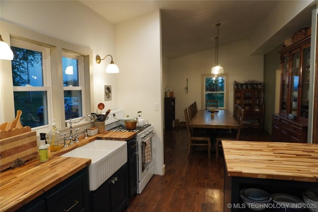 kitchen featuring sink, butcher block counters, white range with gas stovetop, pendant lighting, and dark hardwood / wood-style flooring