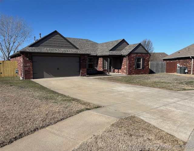 ranch-style home with fence, driveway, an attached garage, a front lawn, and brick siding