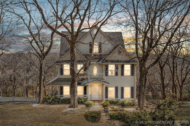 view of front of property with a front yard and a balcony