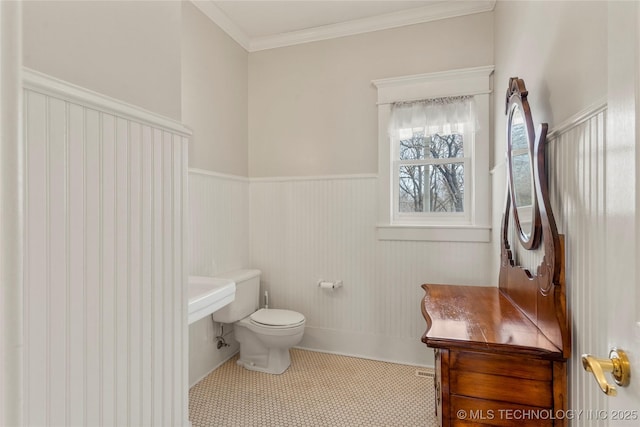7637 S 26th W Ave, Tulsa, OK 74037 - bathroom with a wainscoted wall, toilet, ornamental molding, and tile patterned flooring