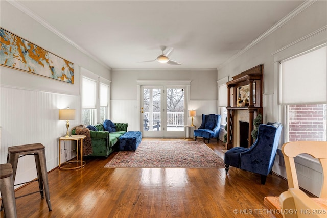 7637 S 26th W Ave, Tulsa, OK 74037 - sitting room with a ceiling fan, wood finished floors, wainscoting, a fireplace, and ornamental molding