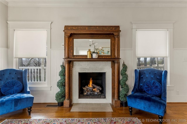 7637 S 26th W Ave, Tulsa, OK 74037 - sitting room featuring a tile fireplace, crown molding, plenty of natural light, wood finished floors, and a wainscoted wall