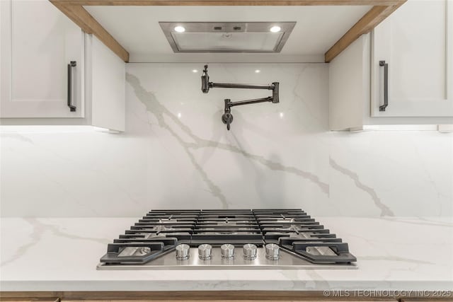 2982 E 145th St S, Bixby, OK 74008 - interior details featuring white cabinets, decorative backsplash, and stainless steel gas stovetop