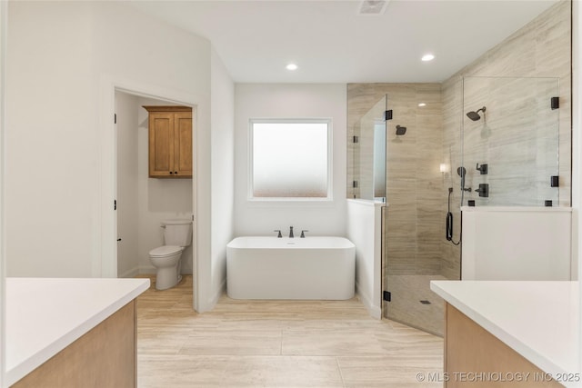 2982 E 145th St S, Bixby, OK 74008 - bathroom featuring a shower stall, vanity, a freestanding bath, toilet, and recessed lighting