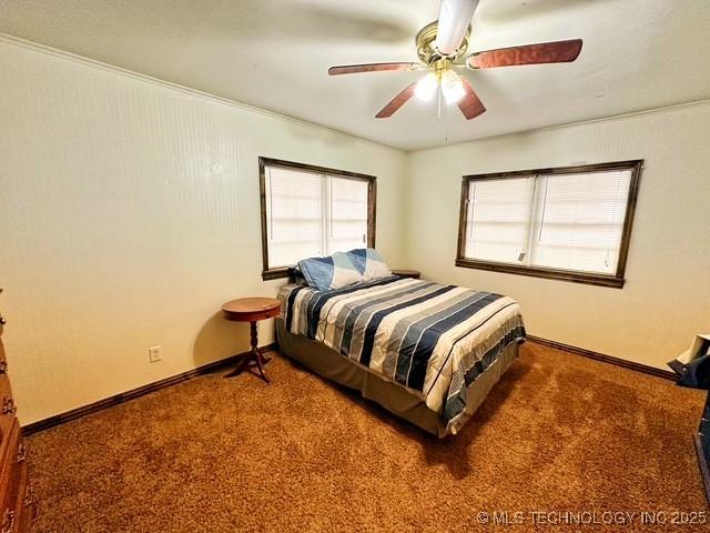 bedroom with dark carpet, baseboards, and ceiling fan