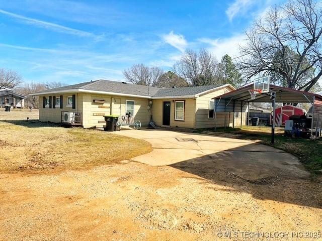 view of front of house featuring concrete driveway and a detached carport