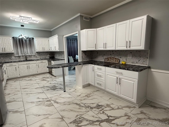 kitchen with sink, white cabinetry, pendant lighting, crown molding, and decorative backsplash