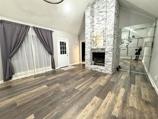 unfurnished living room featuring a fireplace, lofted ceiling, a textured ceiling, and dark hardwood / wood-style floors