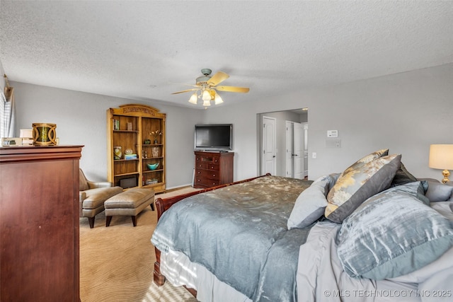 bedroom featuring a textured ceiling, a ceiling fan, and light colored carpet