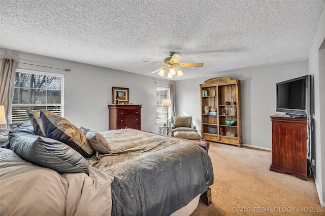 bedroom featuring a ceiling fan, light colored carpet, a textured ceiling, and multiple windows