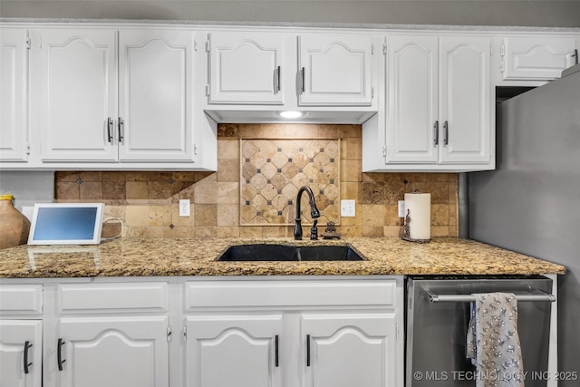 kitchen with backsplash, a sink, and white cabinetry